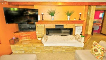 Electric fireplace in beamed ceiling living room.