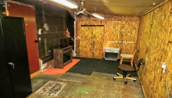 Workshop or storage room with direct access to attached garage and outside.