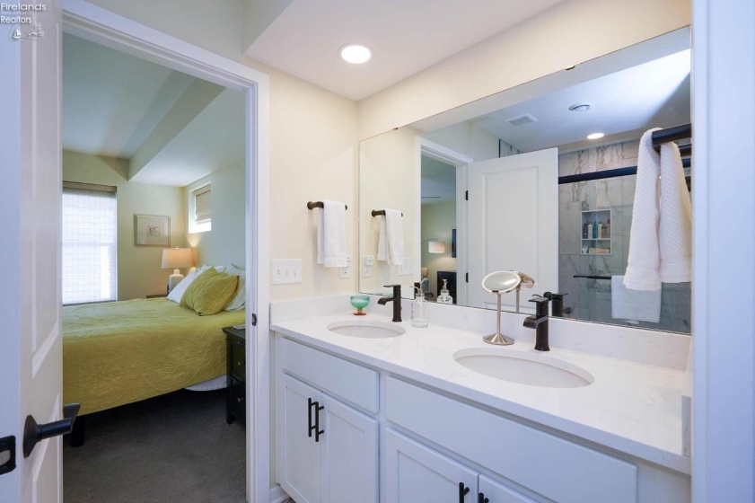 Master bathroom with dual sinks, view of the shower is in the mirror.