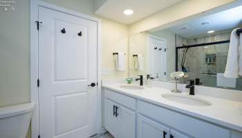 Master bathroom with dual sinks, view of the shower is in the mirror.