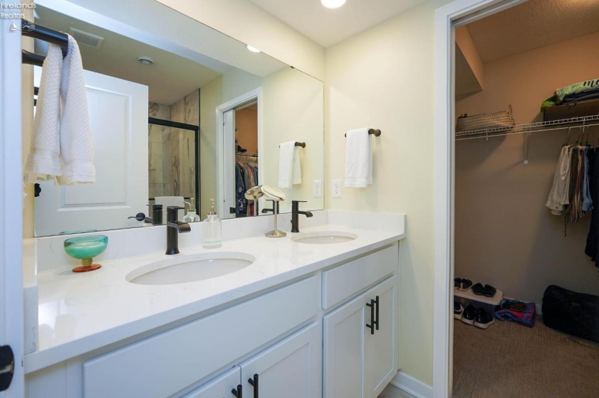 Master bathroom with dual sinks, view of the walk-in closet.