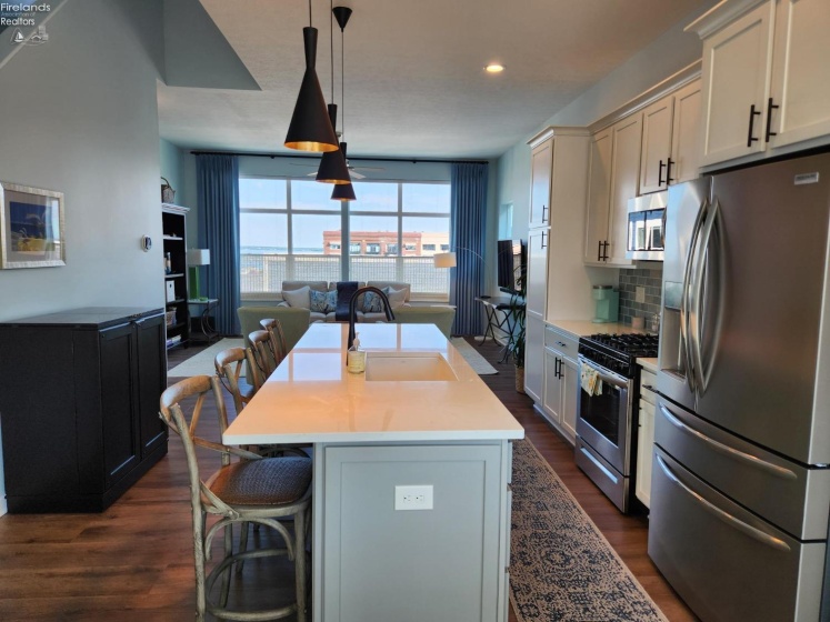 3rd Floor eat-in kitchen with large granite counter top island to the living room.