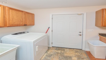 Laundry room with door leading out to backyard.