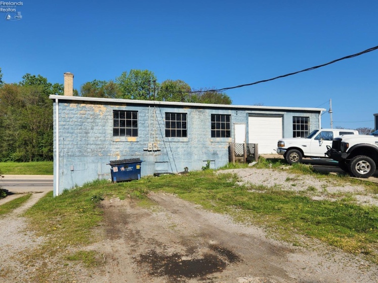 Back view of the block building, newer gutters and downspouts, driveway on the left goes with this property.