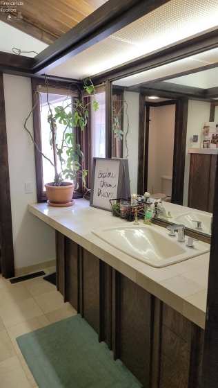 Main floor full bath.  Commode and shower are in a separate room from vanity and storage.