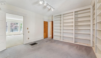 Library/Den/Guest/Hobby room with hallway access to half bath downstairs. Built-in floor to ceiling bookshelves. Hardwood floor underneath in good shape per owner.