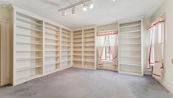 Library/Den/Guest/Hobby room with hallway access to half bath downstairs. Built-in floor to ceiling bookshelves. Hardwood floor underneath in good shape per owner.