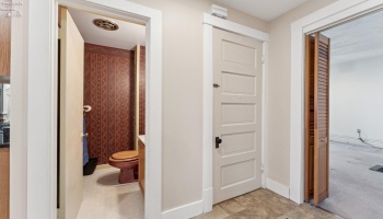 Hallway with half bath directly accessed from formal dining room, kitchen as well as the library/den