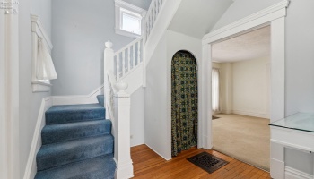 Entry foyer with coat closet and built-in console. Beautiful staircase leading to upstairs with two operable windows for great cross-ventilation