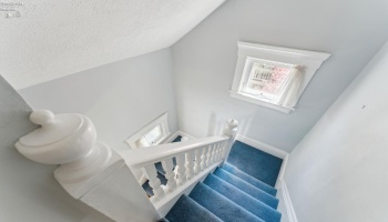 Beautiful staircase leading back downstairs to the entry foyer. Two operable windows for cross-ventilation