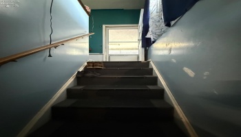 Stairwell going to basement located off garage and kitchen entry way