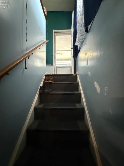 Stairwell going to basement located off garage and kitchen entry way