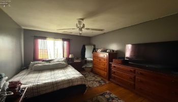 Larger bedroom with natural hardwood floors. Ceilings will need to be refinished.