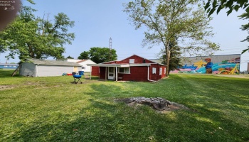 Back of the home and back of the detached garage, large commercial building is across the street.